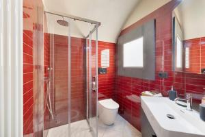 a red tiled bathroom with a toilet and a shower at Il Cappellaio Matto in Alessandria +20 photos
