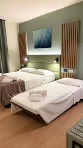 a hotel room with two beds with towels on them at Hotel Milazzo Smart in Milazzo +69 photos