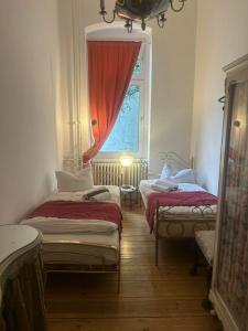 een kamer met drie bedden en een raam bij Kant in Berlijn