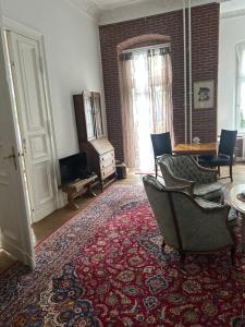 een woonkamer met een bank en stoelen op een tapijt bij Kant in Berlijn