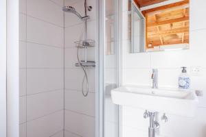 un baño con lavabo y ducha en Saskia, en Hollum 15 fotos más