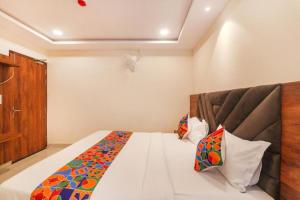a bedroom with a large bed with a wooden headboard at RROOMS Rachna Inn in Lucknow