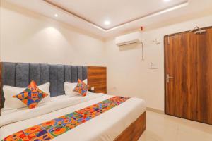 a bedroom with a large bed and a wooden cabinet at RROOMS Rachna Inn in Lucknow +2 photos
