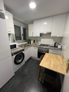a kitchen with a washing machine and a table at Habitaciones en la calle Rambla in Barcelona