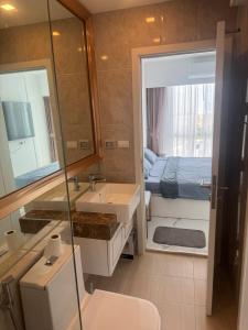 a bathroom with a sink and a mirror and a bed at Empire Tower Suite - Luxe 1BR near the Beach in Jomtien Beach +12 photos