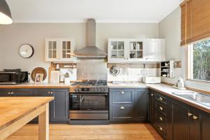 a kitchen with blue cabinets and a stove top oven at Countryside Escape Near Margate Village in Margate