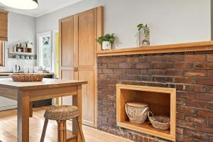 a kitchen with a brick fireplace with a table and chairs at Countryside Escape Near Margate Village in Margate +26 photos