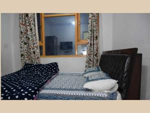 a bed in a room with a window and a couch at Hotel O Murawah in Rezan
