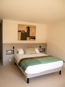 a bedroom with a bed and a painting on the wall at Villa Adeona in Zonza +63 photos