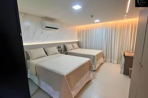 a hotel room with two beds and a desk at LM One Jardim Oceania in João Pessoa +63 photos