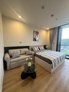 下龙湾Studio ICON40的一间卧室，里面有一张床、一张沙发和一张桌子