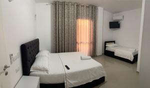 a small room with two beds and a window at Hotel Italia in Golem