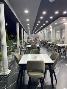 a dining room with tables and chairs and columns at Hotel Italia in Golem