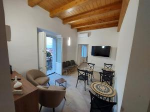 a living room with tables and chairs and a television at Al Monumento bed & breakfast in Amantea