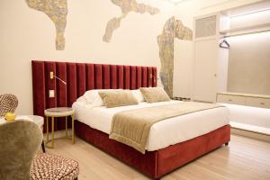 a bedroom with a large bed with a red headboard at Stanze del David Place in Florence