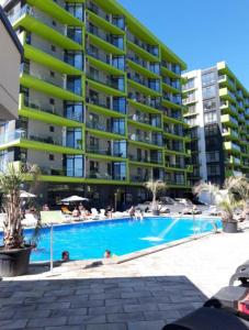 a swimming pool in front of a large apartment building at Mamaia Nord Promenada - Beach Pool si Spa Resort langa plaja in Mamaia Nord