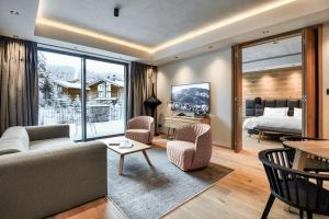a living room with a couch and a bedroom at Swissôtel Damian Jasna in Demanovska Dolina