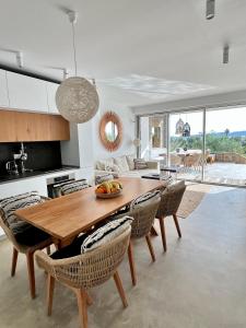 a kitchen and dining room with a wooden table and chairs at VistaWave Sea View Villa in Gialova