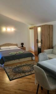 a bedroom with a bed and a couch and a chair at Guest House SAM-WATER in Ðenovići