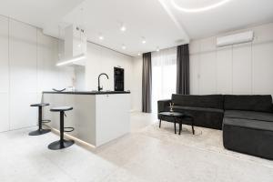 a living room with a black couch and a kitchen at Royalton Urbana in Oradea