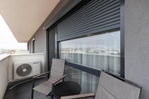 a room with a balcony with two chairs and a window at Royalton Urbana in Oradea