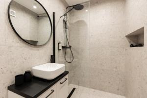 a bathroom with a sink and a shower with a mirror at Royalton Urbana in Oradea +27 photos