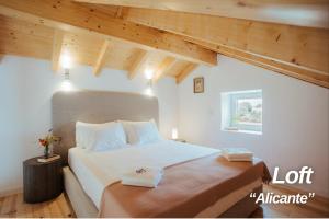 a bedroom with a large white bed with wooden ceilings at Alojamentos Plansel - No Coração das Vinhas do Alentejo in Montemor-o-Novo +54 photos