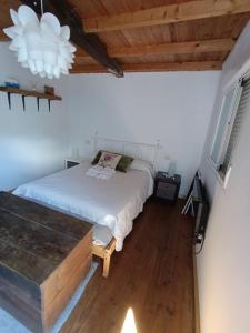 a bedroom with a white bed and a wooden floor at La Cabaña de Morgan, Refugio con alma en el corazón de Galicia in Arnoia