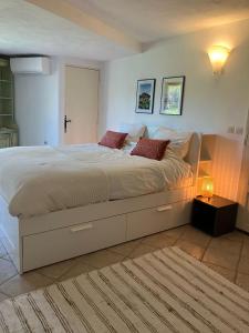 een slaapkamer met een groot wit bed met rode kussens bij Les Bosquets in Lorgues +22 foto's