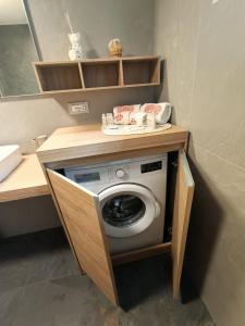 een wasmachine en droger onder een aanrecht in de badkamer bij Casa Soraya 2 in Falcade