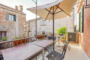 a balcony with a table and chairs and an umbrella at Santo Stefano Palace in Venice