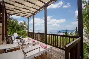 eine Terrasse mit Tisch und Stühlen auf einem Deck in der Unterkunft The Marmara Bodrum - Adult Only in Bodrum City