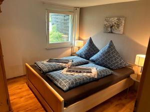 a bed with blue pillows on it in a room at Usedomer Landhaus in Kamminke