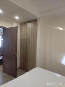 a bedroom with a bed and a wooden door at Hotel Supreme in Gurgaon