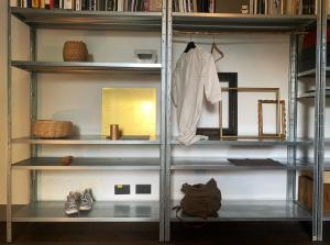 a shelving unit with clothes and other items on it at cascina lago in Montorfano +7 photos