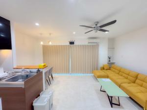 a living room with a couch and a sink at 恩納村仲泊海の見える2LDkアパート in Onna