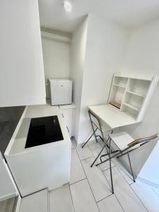 a white kitchen with a desk and a chair at Residence Zar 9 in Trieste +11 photos