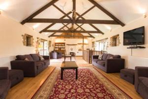 a living room with couches and a flat screen tv at Winnow Barn in Liskeard