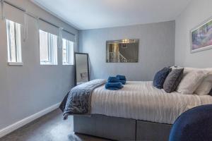 a bedroom with a large bed with blue pillows at ORME RISE - Beautiful first floor apartment in Llandudno