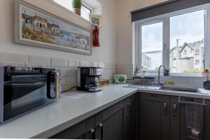a kitchen with a sink and a stove top oven at ORME RISE - Beautiful first floor apartment in Llandudno +13 photos