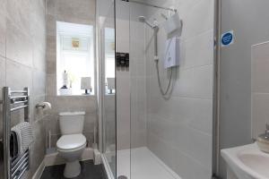 a bathroom with a shower and a toilet and a sink at ORME RISE - Beautiful first floor apartment in Llandudno