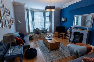 a living room with a couch and a table at ORME RISE - Beautiful first floor apartment in Llandudno
