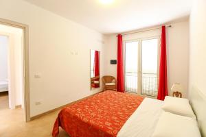 a bedroom with a bed and a large window at Family Suite Porto Vecchio in Lampedusa