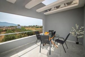 Un comedor con mesa y sillas y una gran ventana. en Elhasa Laganas Villa BY "ELITE", en Laganas