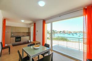 a kitchen and dining room with a view of the water at Family Suite Porto Vecchio in Lampedusa