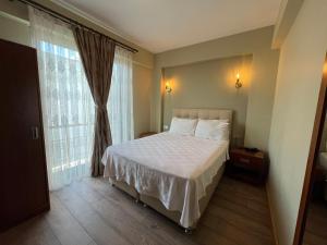 a bedroom with a bed and a large window at Alâ Avsa Hotel in Avşa Adası