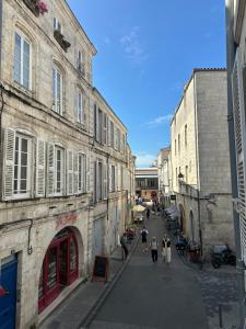 a group of people walking down a street with buildings at L'Oasis Marin meublé, lumineux et cosy à 1min à pied du marché dans l'hyper centre de La Rochelle avec TV et Wifi in La Rochelle +13 photos