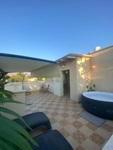 a bath tub sitting on a patio with a deck at סוד הנחלים in Sde Nehemia +13 photos