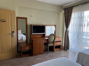 a hotel room with a desk with a television and a bed at Alâ Avsa Hotel in Avşa Adası