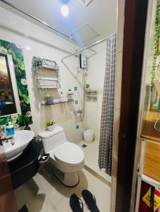 a bathroom with a toilet and a sink at Casa Tagpuan in Manhattan ParkWay in Manila